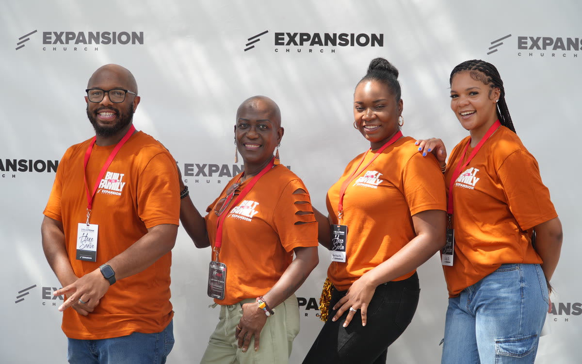 Four members of the Expansion team in orange shirts at Homecoming