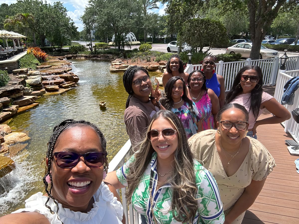 The Women’s Tribe together outdoors by a pond